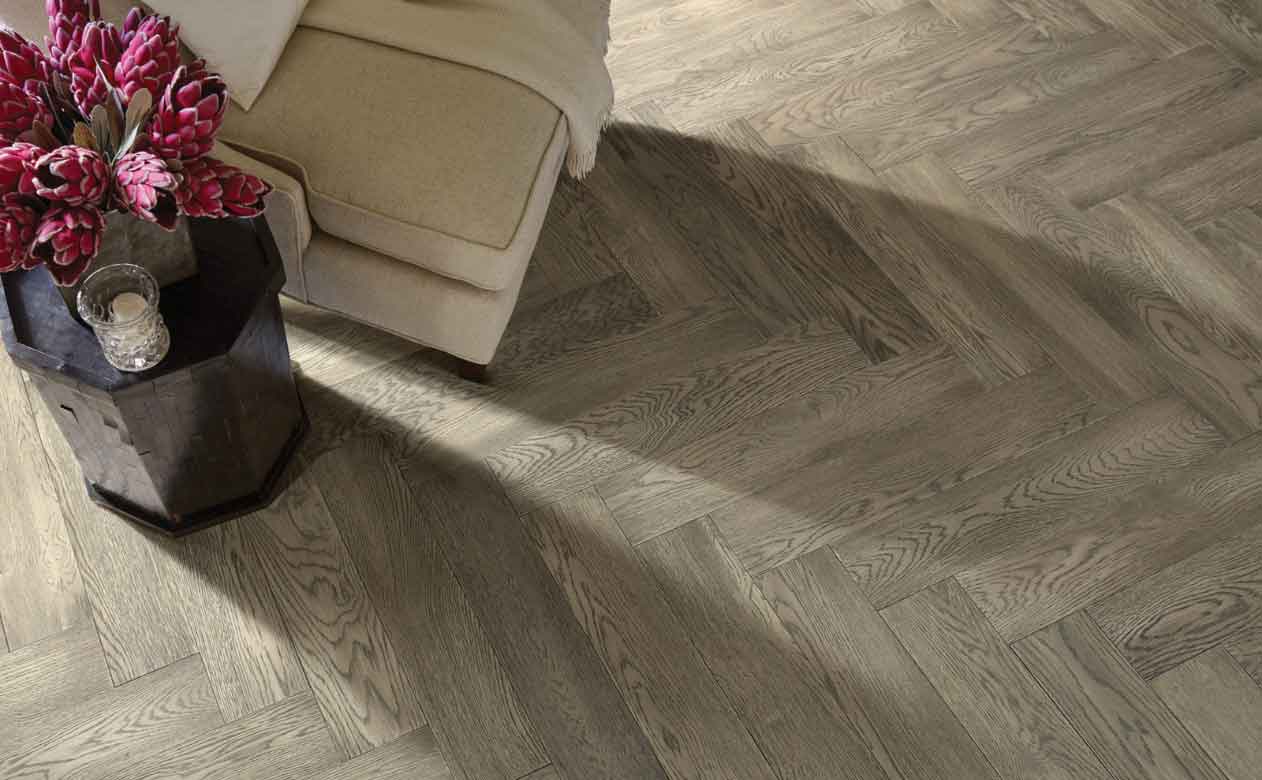 Herringbone patterned Hardwood Flooring in Living Room with Chair and Table